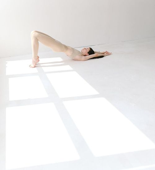 Woman in a calm yoga pose in a bright studio.
